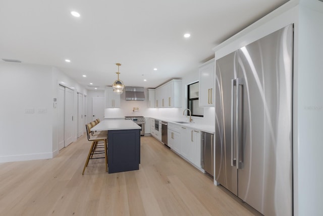 510 Putter Ln, Longboat Key, FL 34228 - kitchen with appliances with stainless steel finishes, a center island, a breakfast bar, light wood finished floors, and white cabinets