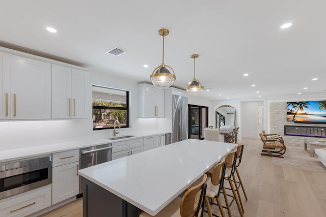 510 Putter Ln, Longboat Key, FL 34228 - kitchen featuring light wood-style floors, a kitchen breakfast bar, recessed lighting, stainless steel appliances, and a kitchen island