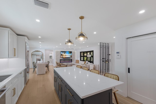 510 Putter Ln, Longboat Key, FL 34228 - kitchen featuring white cabinetry, light wood-style flooring, a kitchen island, open floor plan, and recessed lighting