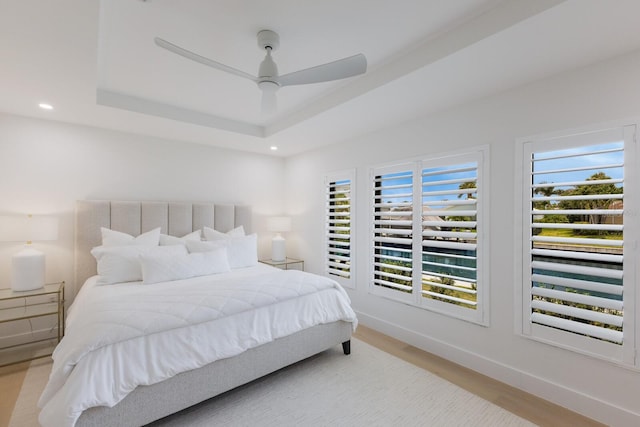 510 Putter Ln, Longboat Key, FL 34228 - bedroom featuring multiple windows, a tray ceiling, light wood-type flooring, recessed lighting, and ceiling fan