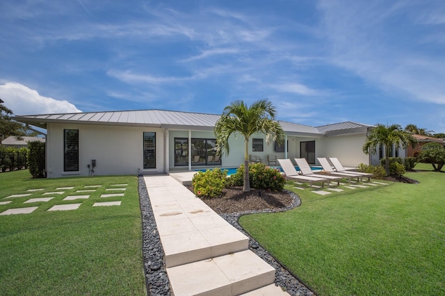 510 Putter Ln, Longboat Key, FL 34228 - rear view of property with a metal roof, a standing seam roof, a yard, and stucco siding