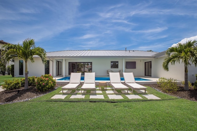 510 Putter Ln, Longboat Key, FL 34228 - back of property featuring stucco siding, a yard, a metal roof, and a standing seam roof