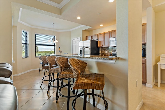 7121 River Hammock Dr Unit 102, Bradenton, FL 34212 - kitchen with appliances with stainless steel finishes, a kitchen bar, light tile patterned floors, recessed lighting, and tasteful backsplash