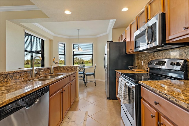 7121 River Hammock Dr Unit 102, Bradenton, FL 34212 - kitchen featuring stainless steel appliances, brown cabinetry, tasteful backsplash, dark stone counters, and crown molding