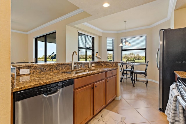 7121 River Hammock Dr Unit 102, Bradenton, FL 34212 - kitchen with stainless steel appliances, healthy amount of natural light, brown cabinets, dark stone countertops, and crown molding