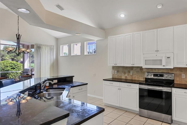 7960 Hampton Ct, University Park, FL 34201 - kitchen with stainless steel electric range oven, white microwave, light tile patterned floors, decorative backsplash, and lofted ceiling