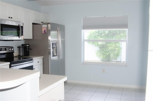 671 E Baffin Dr, Venice, FL 34293 - kitchen with stainless steel appliances, light countertops, white cabinets, and light tile patterned flooring