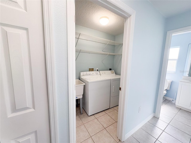 671 E Baffin Dr, Venice, FL 34293 - washroom with washing machine and dryer, light tile patterned floors, and a textured ceiling