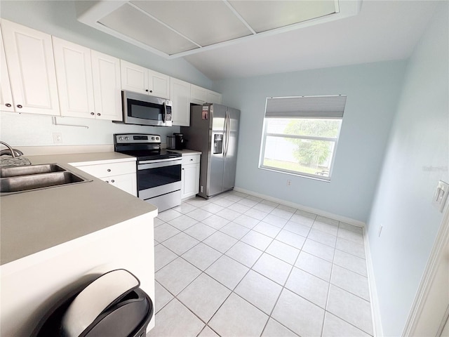 671 E Baffin Dr, Venice, FL 34293 - kitchen featuring appliances with stainless steel finishes, vaulted ceiling, white cabinetry, light tile patterned flooring, and light countertops