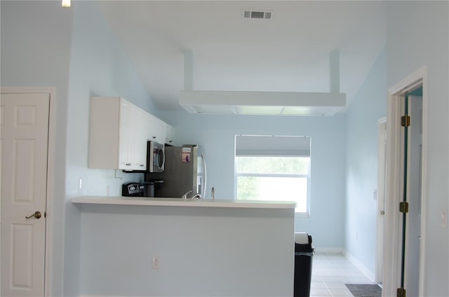 671 E Baffin Dr, Venice, FL 34293 - kitchen with a peninsula, appliances with stainless steel finishes, light tile patterned flooring, white cabinetry, and light countertops