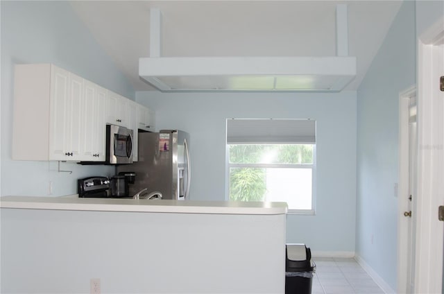 671 E Baffin Dr, Venice, FL 34293 - kitchen with stainless steel appliances, a peninsula, light tile patterned floors, white cabinets, and light countertops