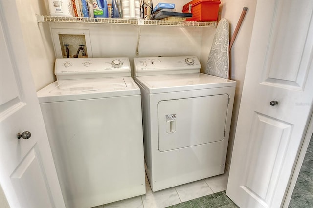 1485 Gulf Of Mexico Dr Unit 101, Longboat Key, FL 34228 - laundry room with washer and dryer and light tile patterned floors