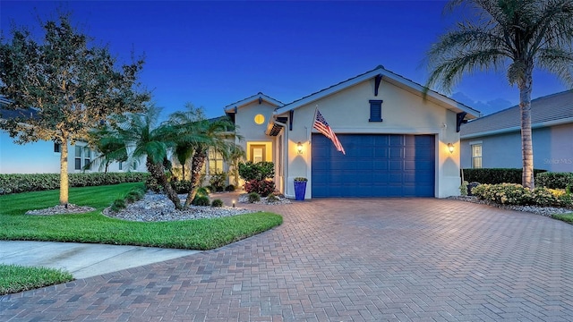 1114 Bearing Ct, Bradenton, FL 34208 - view of front of home featuring stucco siding, decorative driveway, a garage, and a front lawn