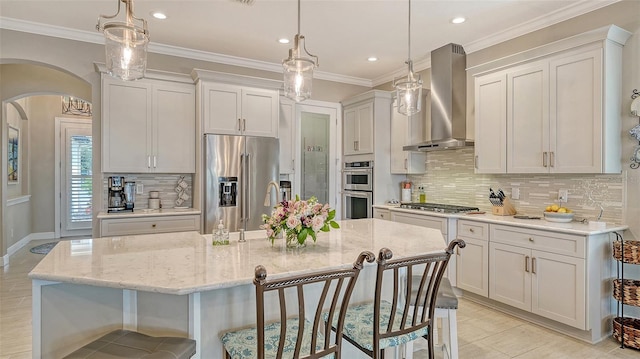 1114 Bearing Ct, Bradenton, FL 34208 - kitchen featuring stainless steel appliances, wall chimney range hood, arched walkways, a breakfast bar, and backsplash