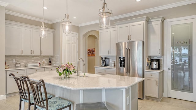 1114 Bearing Ct, Bradenton, FL 34208 - kitchen with high end fridge, decorative backsplash, a breakfast bar area, recessed lighting, and a kitchen island with sink