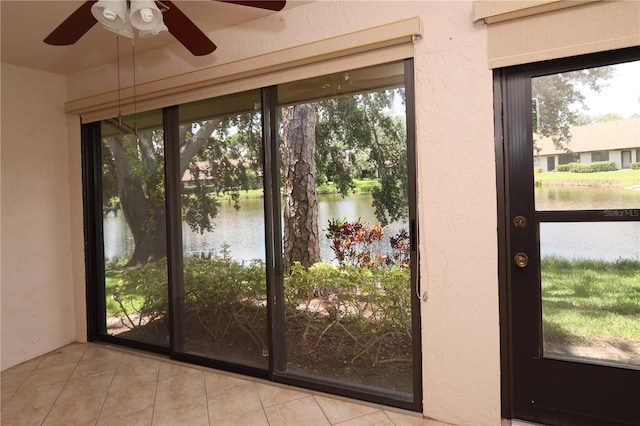 3376 Sandleheath Unit 9, Sarasota, FL 34235 - doorway to outside featuring a water view, tile patterned flooring, ceiling fan, and a textured wall