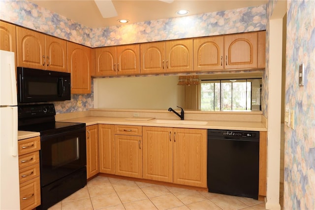 3376 Sandleheath Unit 9, Sarasota, FL 34235 - kitchen featuring black appliances, light countertops, light tile patterned floors, and wallpapered walls