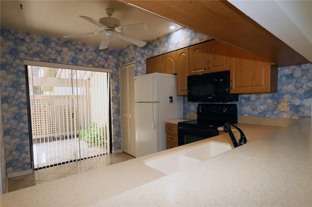 3376 Sandleheath Unit 9, Sarasota, FL 34235 - kitchen featuring black appliances, wallpapered walls, light countertops, light tile patterned floors, and ceiling fan