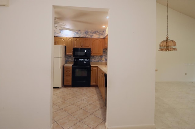 3376 Sandleheath Unit 9, Sarasota, FL 34235 - kitchen with black appliances, decorative backsplash, light countertops, and light tile patterned floors