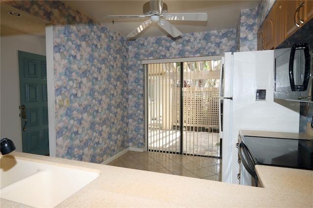 3376 Sandleheath Unit 9, Sarasota, FL 34235 - kitchen featuring light tile patterned floors, black microwave, electric range, wallpapered walls, and ceiling fan