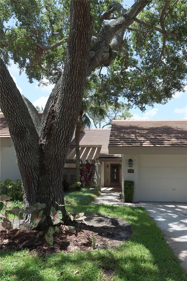 3376 Sandleheath Unit 9, Sarasota, FL 34235 - view of front of house featuring an attached garage, stucco siding, a tile roof, and concrete driveway