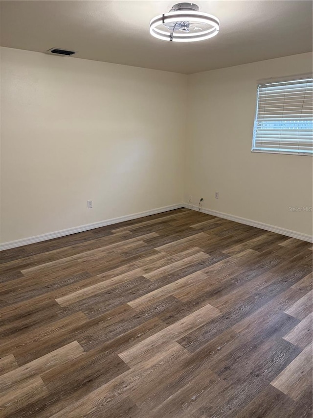 4424 Coco Ridge Cir, Sarasota, FL 34233 - spare room with baseboards and dark wood-type flooring