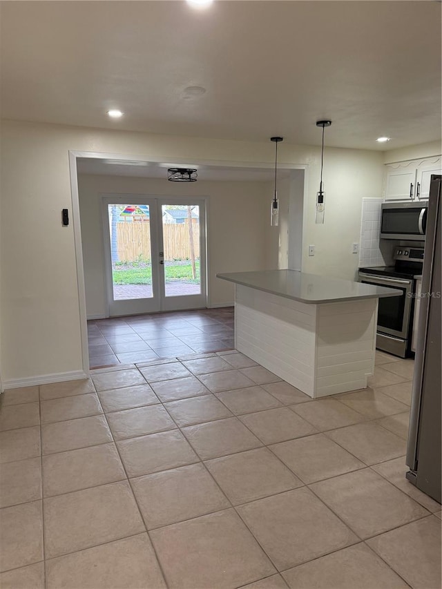 4424 Coco Ridge Cir, Sarasota, FL 34233 - kitchen with appliances with stainless steel finishes, light tile patterned floors, white cabinetry, recessed lighting, and a kitchen island