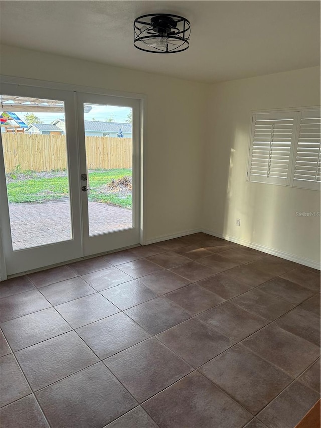 4424 Coco Ridge Cir, Sarasota, FL 34233 - empty room featuring healthy amount of natural light, french doors, and dark tile patterned flooring