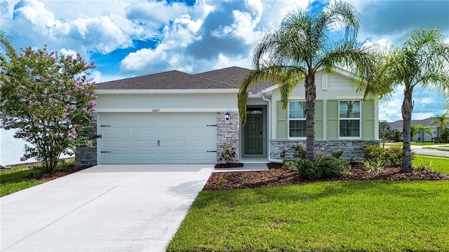 13829 Camden Crest Ter, Bradenton, FL 34211 - view of front of property featuring stone siding, a garage, concrete driveway, and a front lawn