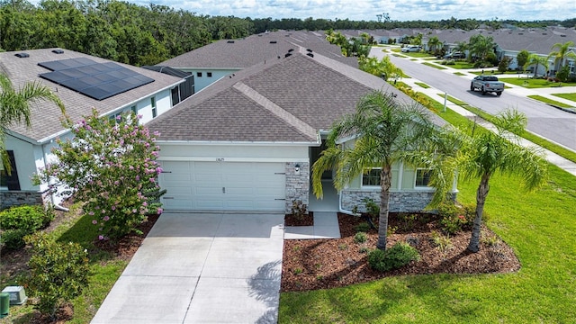 13829 Camden Crest Ter, Bradenton, FL 34211 - view of front of house with stone siding, an attached garage, driveway, a shingled roof, and stucco siding