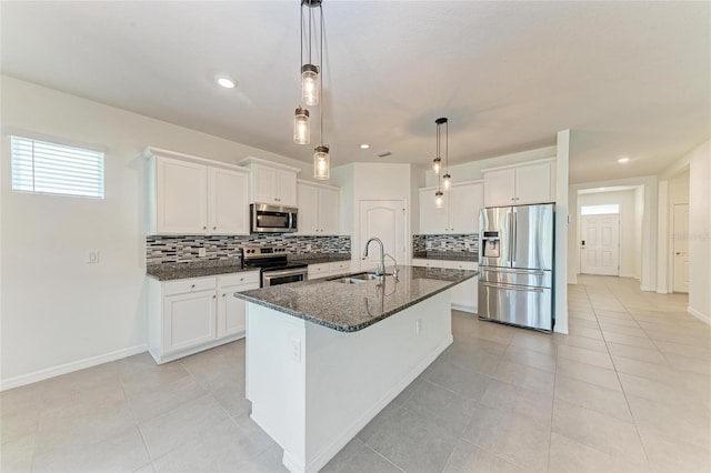 13829 Camden Crest Ter, Bradenton, FL 34211 - kitchen featuring appliances with stainless steel finishes, decorative backsplash, a center island with sink, dark stone countertops, and recessed lighting