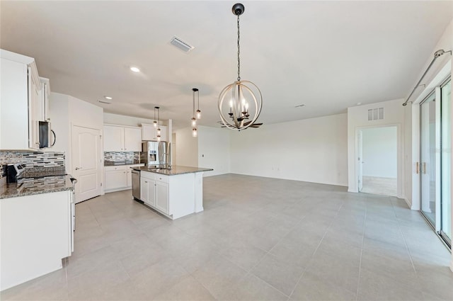 13829 Camden Crest Ter, Bradenton, FL 34211 - kitchen with a chandelier, stainless steel appliances, decorative backsplash, open floor plan, and a kitchen island