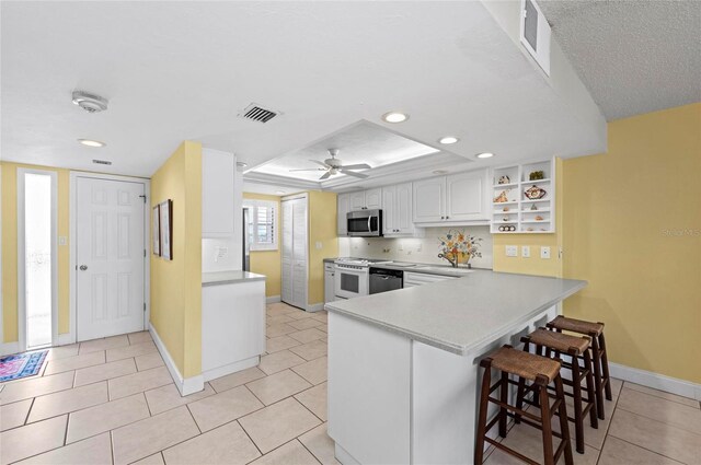6480 Midnight Pass Rd Unit 503, Sarasota, FL 34242 - kitchen with stainless steel microwave, gas range gas stove, a kitchen bar, open shelves, and white cabinetry