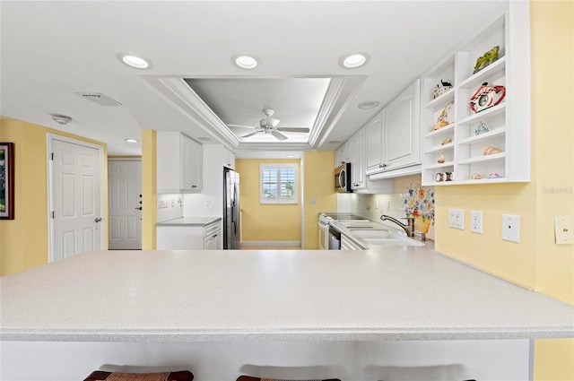 6480 Midnight Pass Rd Unit 503, Sarasota, FL 34242 - kitchen with stainless steel appliances, open shelves, a tray ceiling, a breakfast bar area, and a peninsula