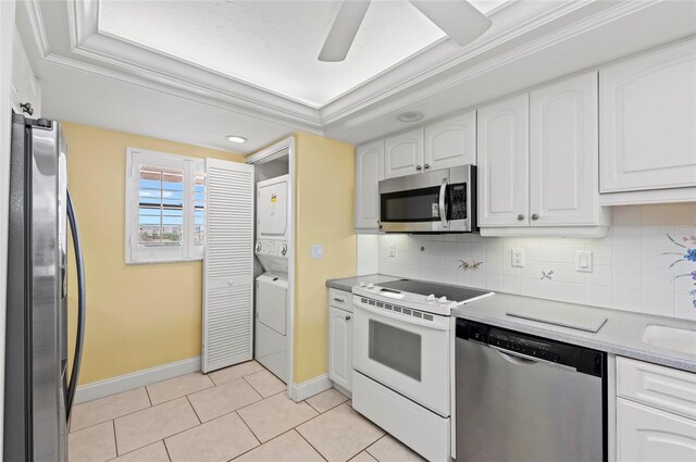 6480 Midnight Pass Rd Unit 503, Sarasota, FL 34242 - kitchen featuring appliances with stainless steel finishes, stacked washing machine and dryer, white cabinetry, tasteful backsplash, and recessed lighting