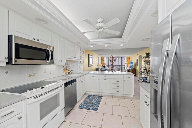 6480 Midnight Pass Rd Unit 503, Sarasota, FL 34242 - kitchen featuring appliances with stainless steel finishes, a peninsula, a tray ceiling, white cabinets, and recessed lighting