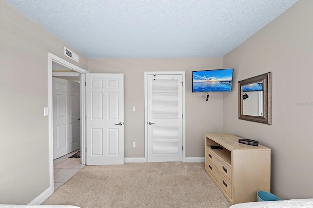 6480 Midnight Pass Rd Unit 503, Sarasota, FL 34242 - bedroom with light carpet, a textured ceiling, and a closet