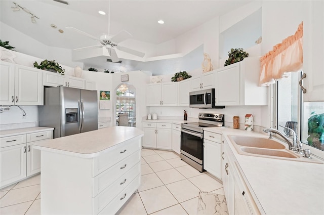 4173 Beach View Ct, Port Charlotte, FL 33948 - kitchen with appliances with stainless steel finishes, a ceiling fan, light tile patterned floors, a kitchen island, and light countertops