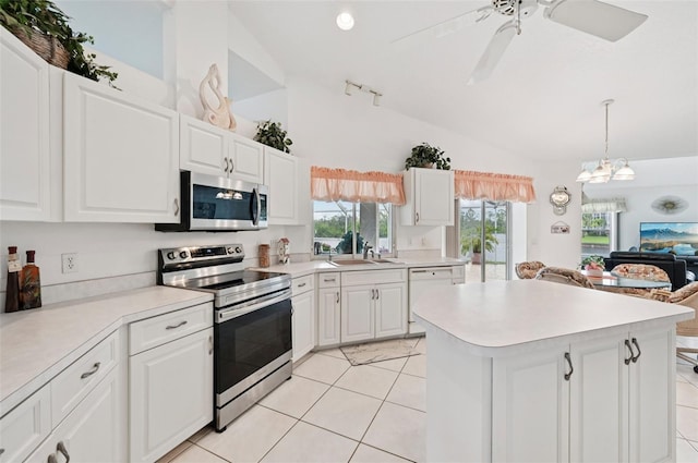 4173 Beach View Ct, Port Charlotte, FL 33948 - kitchen featuring appliances with stainless steel finishes, vaulted ceiling, light tile patterned floors, light countertops, and a center island