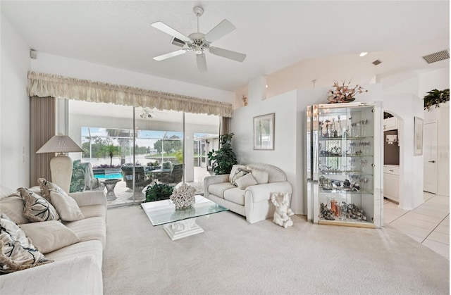 4173 Beach View Ct, Port Charlotte, FL 33948 - living room featuring lofted ceiling, a ceiling fan, light carpet, arched walkways, and light tile patterned floors