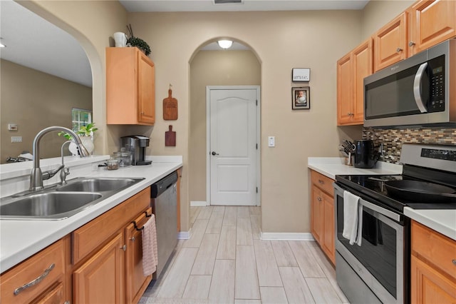311 Cape Harbour Loop Unit 101, Bradenton, FL 34212 - kitchen featuring appliances with stainless steel finishes, arched walkways, backsplash, light countertops, and recessed lighting