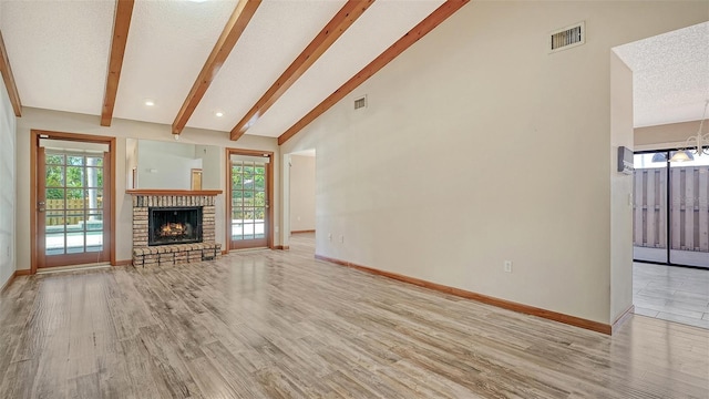 8103 11th Ave NW, Bradenton, FL 34209 - unfurnished living room with light wood-type flooring, a chandelier, healthy amount of natural light, a fireplace, and a textured ceiling