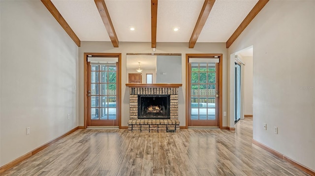 8103 11th Ave NW, Bradenton, FL 34209 - unfurnished living room featuring beam ceiling, wood finished floors, and a fireplace