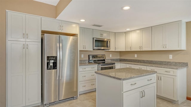 8103 11th Ave NW, Bradenton, FL 34209 - kitchen featuring stainless steel appliances, light stone countertops, recessed lighting, a kitchen island, and light tile patterned flooring