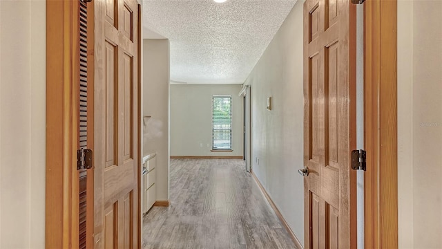 8103 11th Ave NW, Bradenton, FL 34209 - hall featuring a textured ceiling and light wood-type flooring