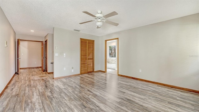 8103 11th Ave NW, Bradenton, FL 34209 - unfurnished bedroom with light wood-style floors, a closet, a textured ceiling, ceiling fan, and ensuite bathroom