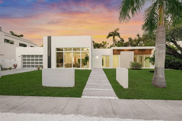 3500 Bay Shore Rd, Sarasota, FL 34234 - contemporary home featuring stucco siding, an attached garage, a front lawn, and driveway