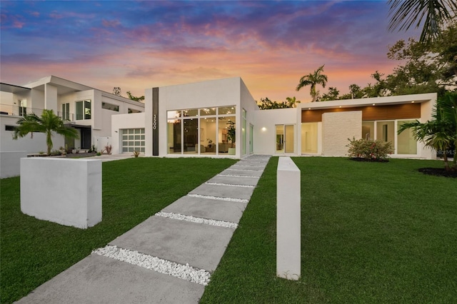3500 Bay Shore Rd, Sarasota, FL 34234 - view of front facade featuring stucco siding, a front lawn, and an attached garage
