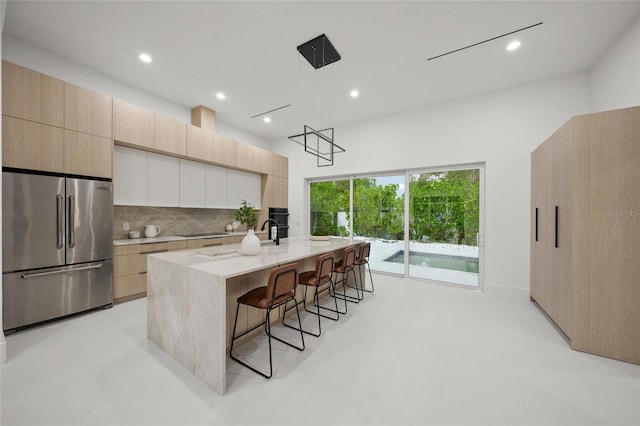 3500 Bay Shore Rd, Sarasota, FL 34234 - kitchen featuring high quality fridge, modern cabinets, light stone counters, decorative backsplash, and recessed lighting
