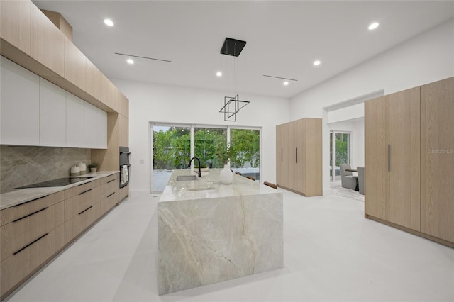 3500 Bay Shore Rd, Sarasota, FL 34234 - kitchen with modern cabinets, black appliances, light stone counters, decorative backsplash, and light brown cabinets